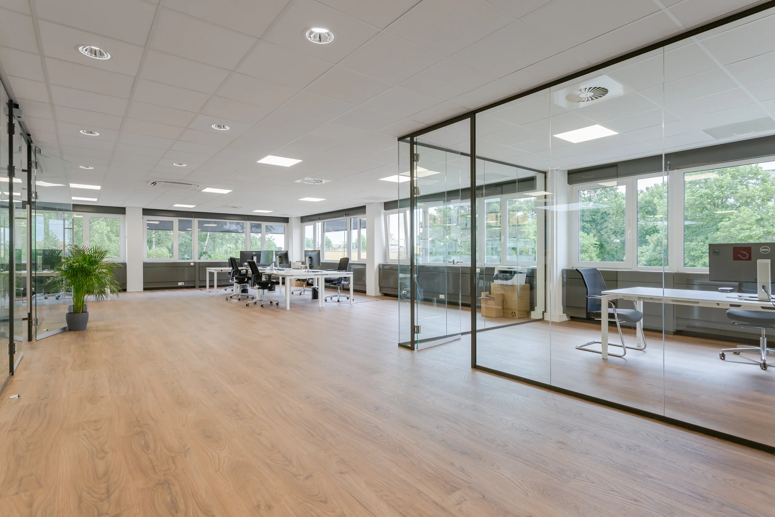 Moderne, ruime kantoorruimte aan de Energieweg met glazen vergaderruimtes en houten vloer.