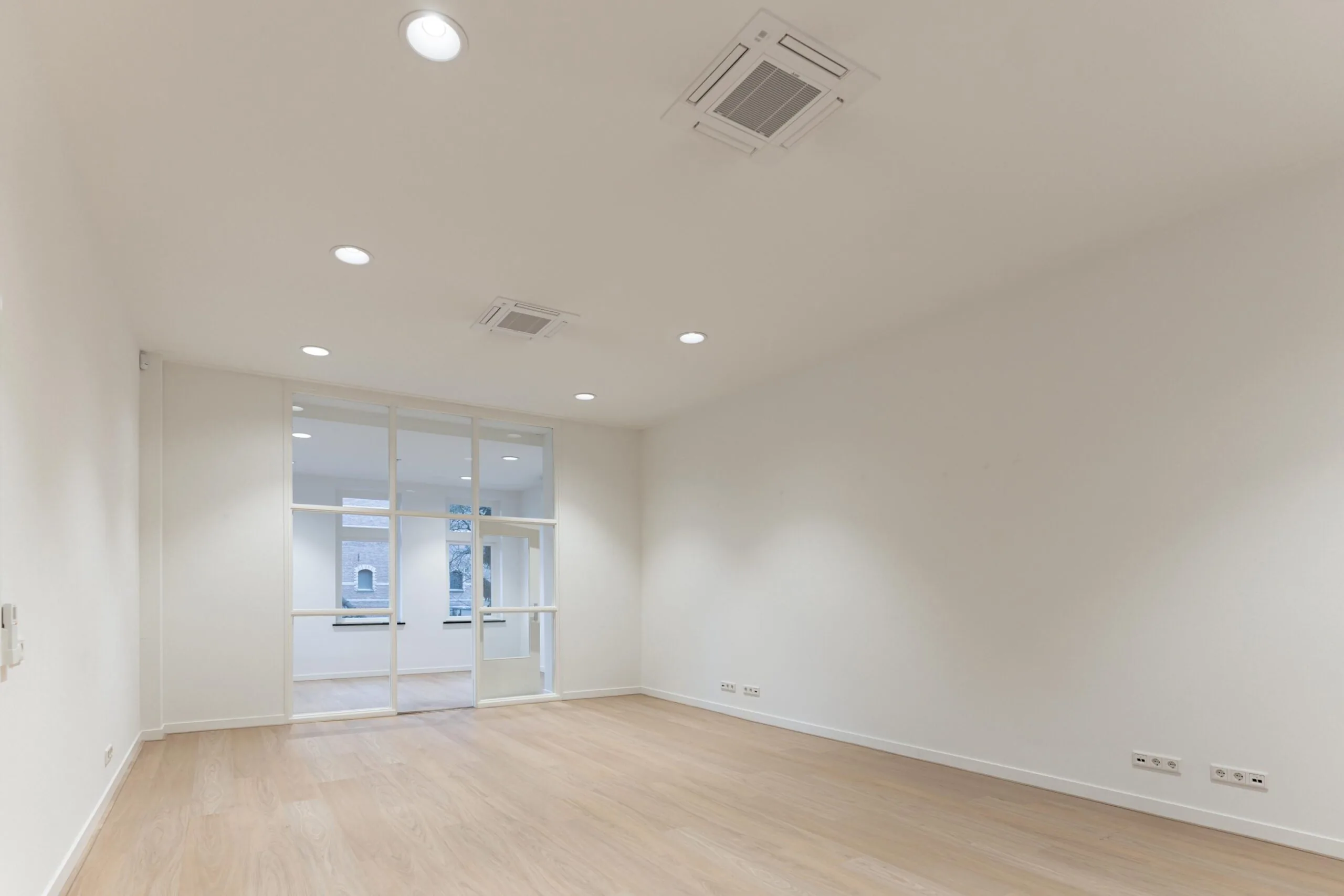 Licht en modern kantoorinterieur aan de Biltstraat met houten vloer en glazen scheidingswand.