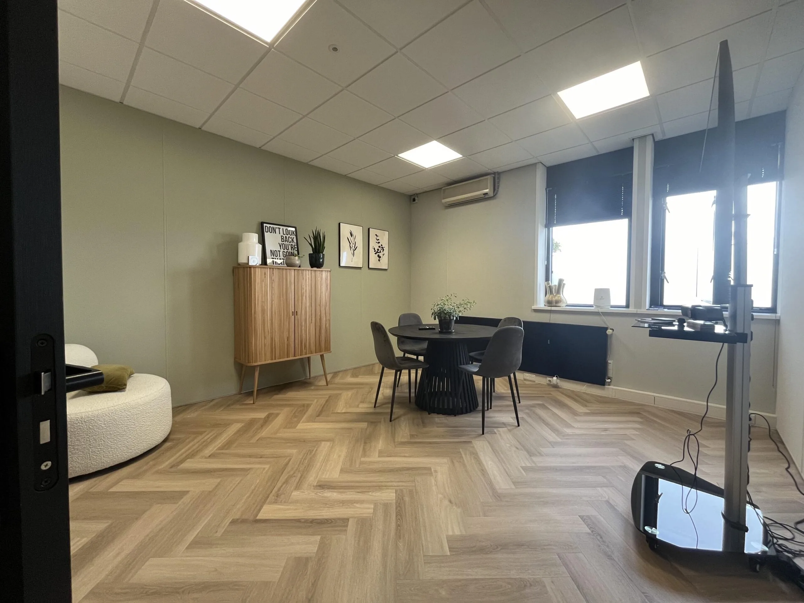 Moderne vergaderruimte met ronde tafel, strak interieur en natuurlijk lichtinval aan de Industrieweg.
