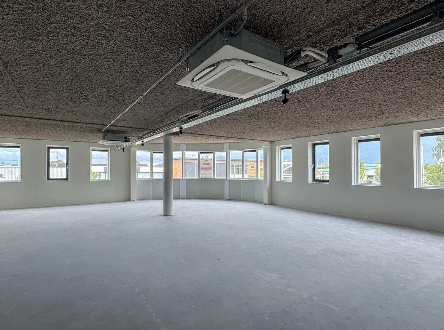 Leeg kantoorruimte met ramen rondom in een modern gebouw aan de Nijverheidslaan.