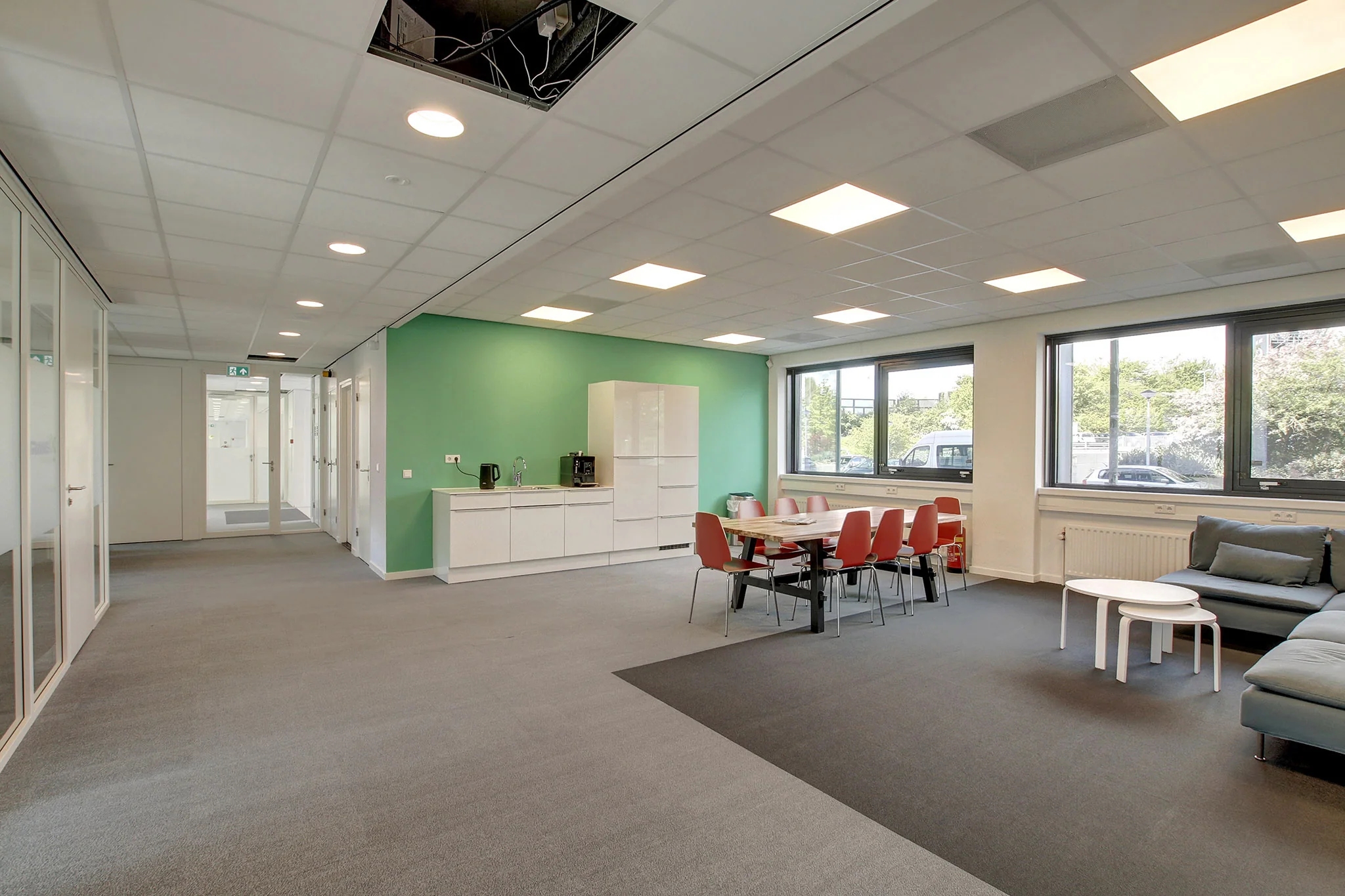 Moderne kantoorruimte aan de Nevelgaarde met pantry, vergadertafel en zithoek.
