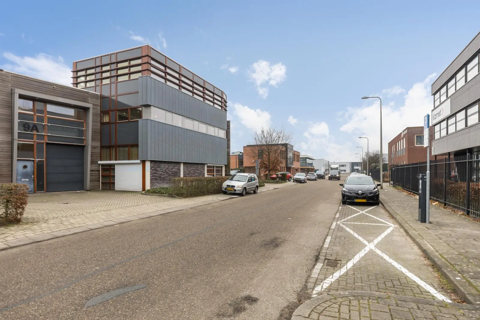 Bedrijventerrein met moderne kantoorpanden aan de Tennesseedreef in Utrecht, met geparkeerde auto's langs de weg.