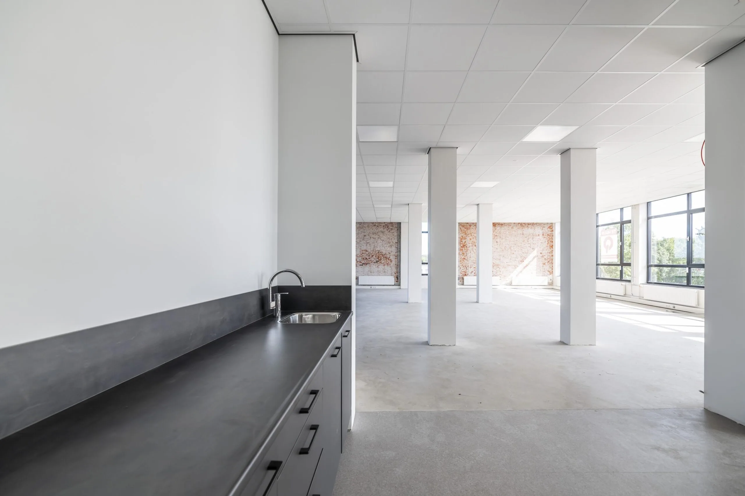 Licht en ruim kantoorpand aan de Lindtsedijk met een kitchenette en grote ramen die uitzicht bieden op de omgeving.