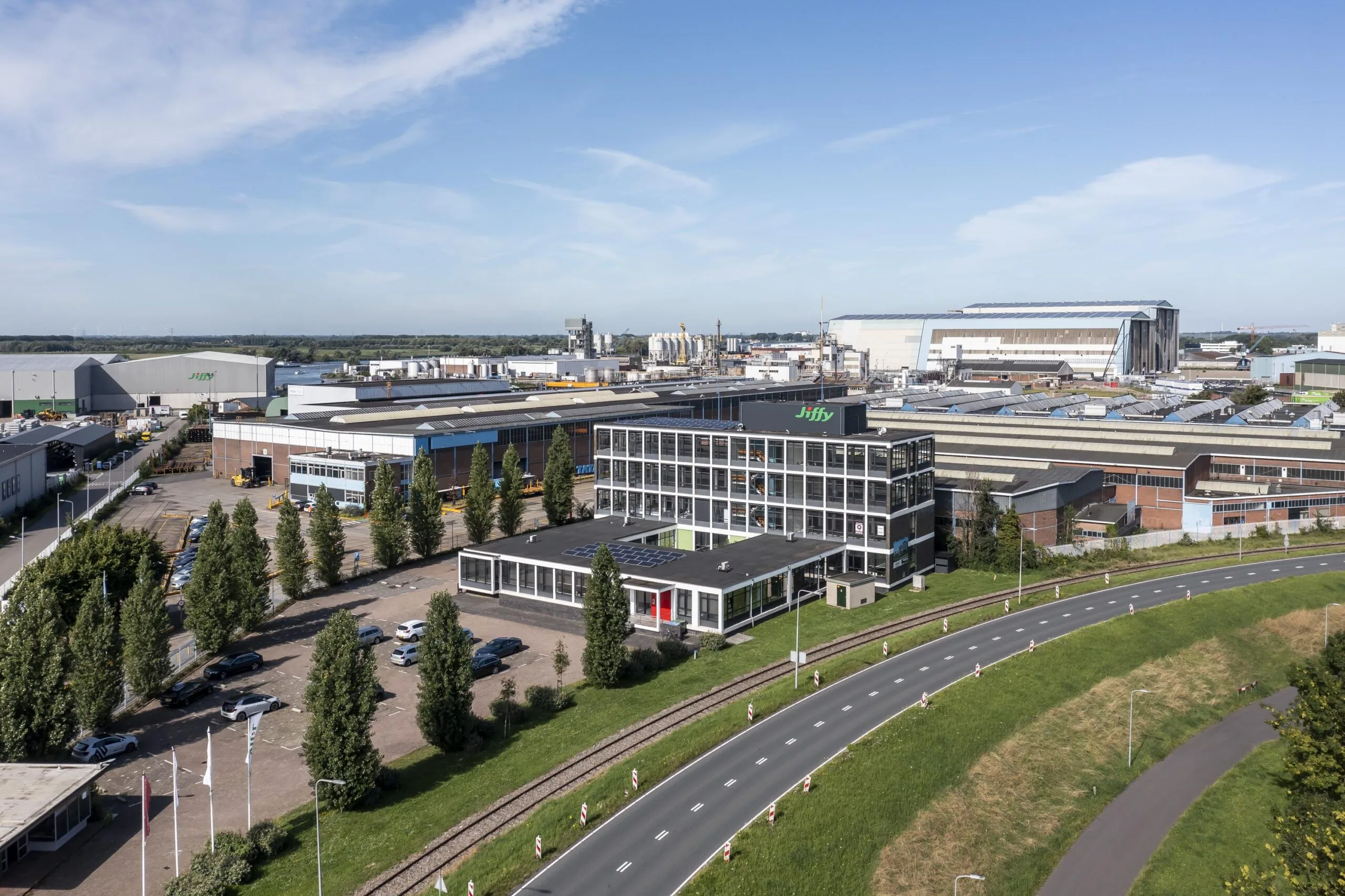 Luchtfoto van een industrieel terrein aan de Lindtsedijk met het kantoorgebouw van Jiffy op de voorgrond.