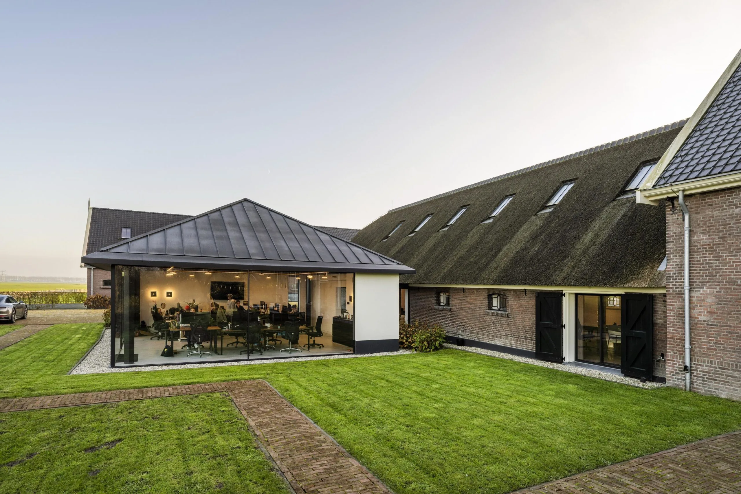 Moderne vergaderruimte met glazen wanden in een gerenoveerde boerderij aan de Gein-Zuid.