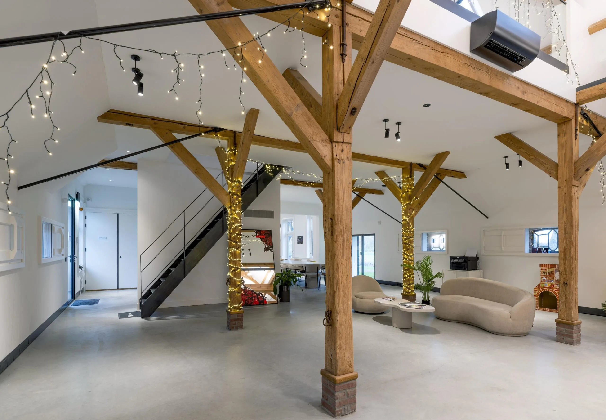 Ruime, modern ingerichte loft in Gein-Zuid met houten balken, sfeerverlichting en een zithoek.