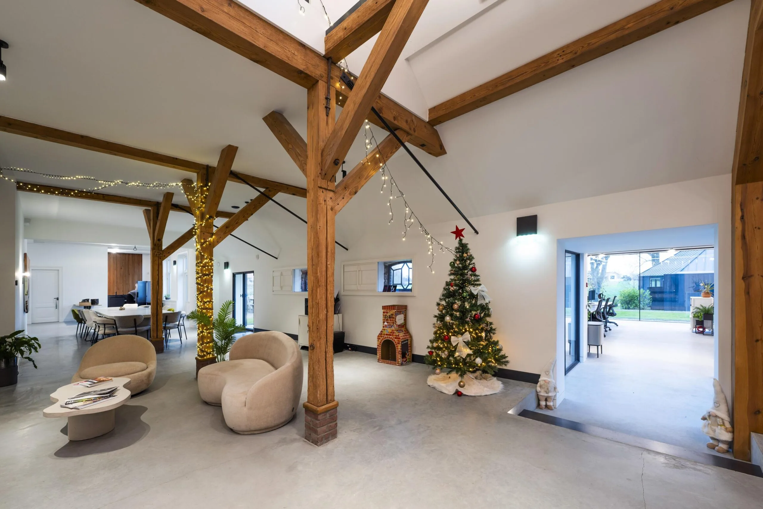 Moderne, sfeervol ingerichte ruimte in Gein-Zuid met houten balken, kerstversiering en een verlichte kerstboom.