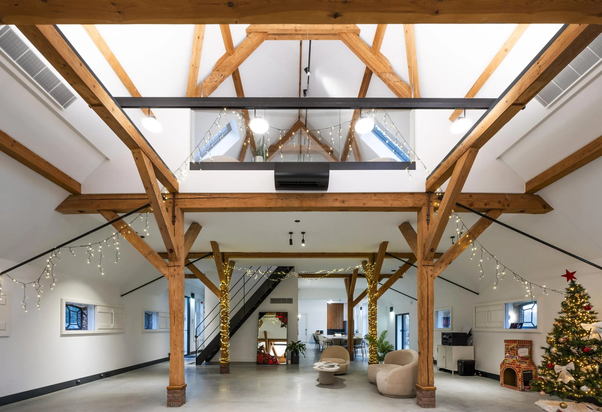 Moderne, open ruimte met houten balken, kerstversiering en een kerstboom in Gein-Zuid.