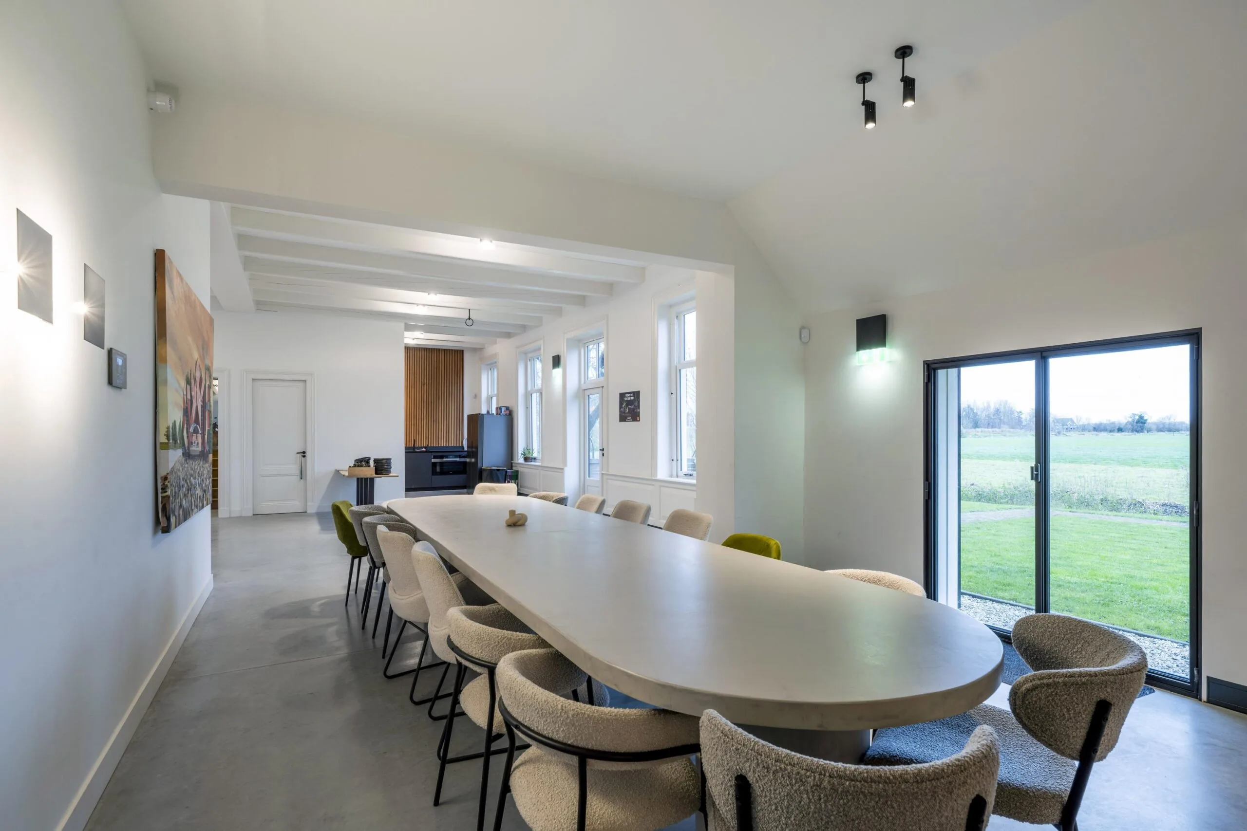Moderne vergaderruimte in Gein-Zuid met lange ovale tafel, designstoelen en uitzicht op groene weilanden.