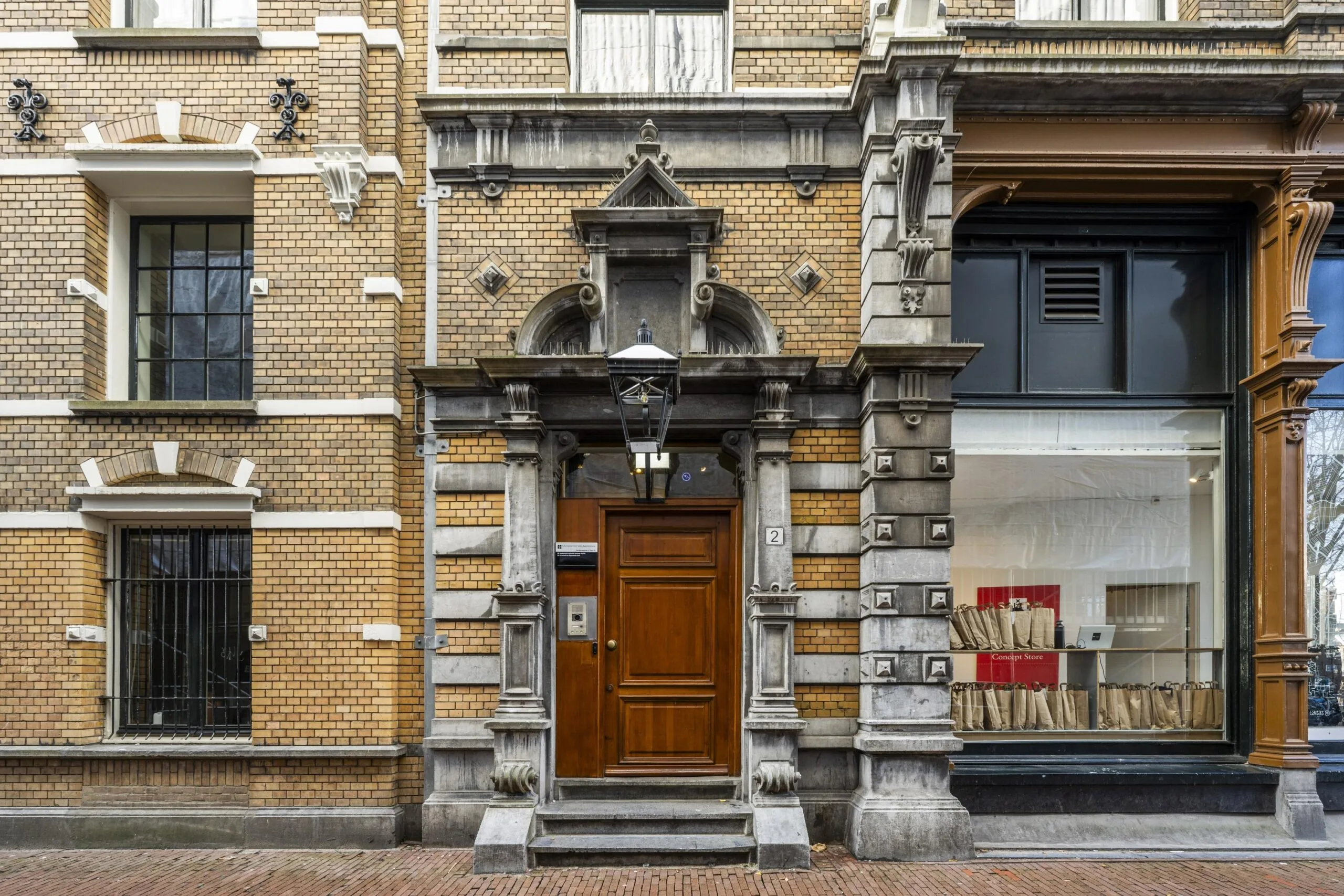Voorgevel van een historisch pand aan de Handboogstraat met een grote houten deur en sierlijke architecturale details.