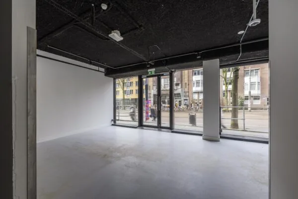 Lege ruimte met grote ramen en uitzicht op de Roetersstraat.