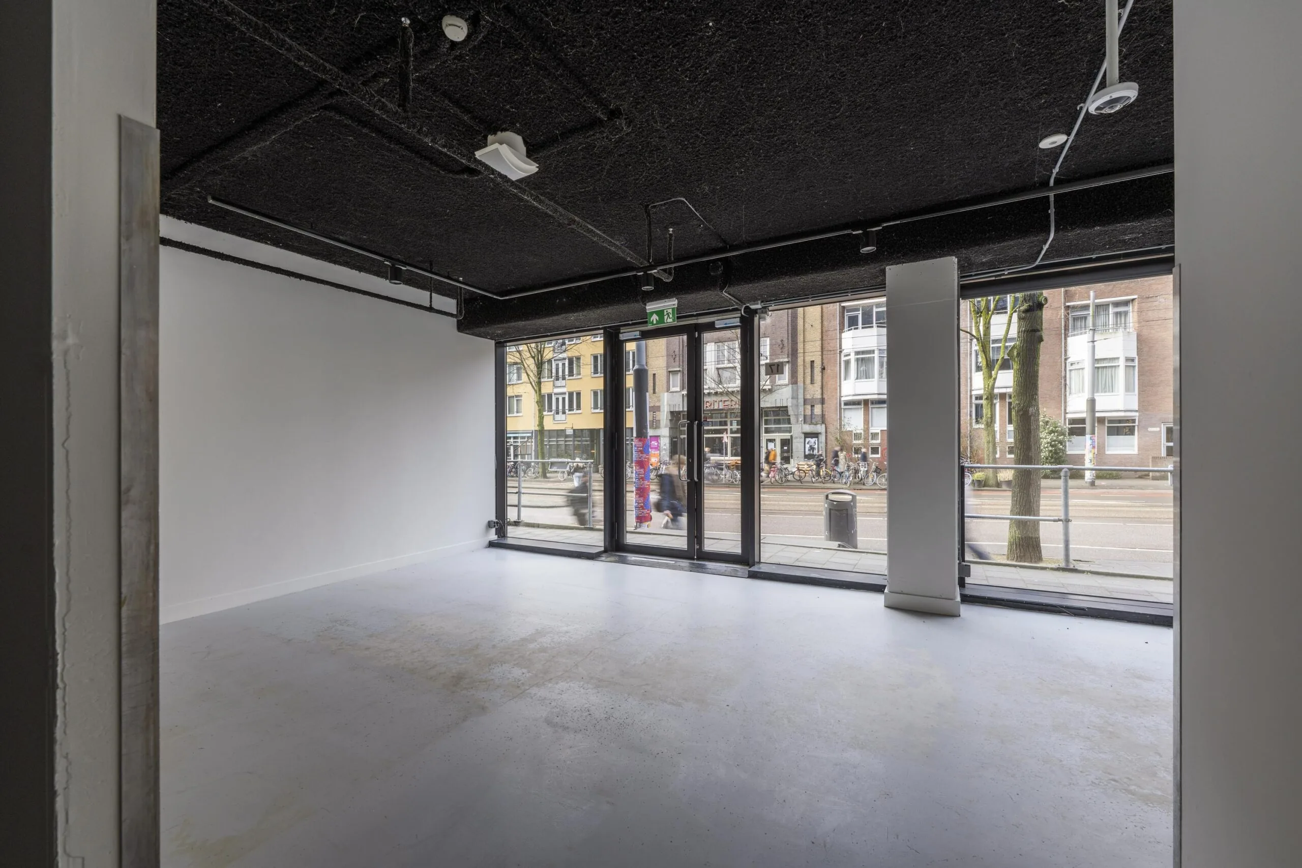 Lege ruimte met grote ramen en uitzicht op de Roetersstraat.