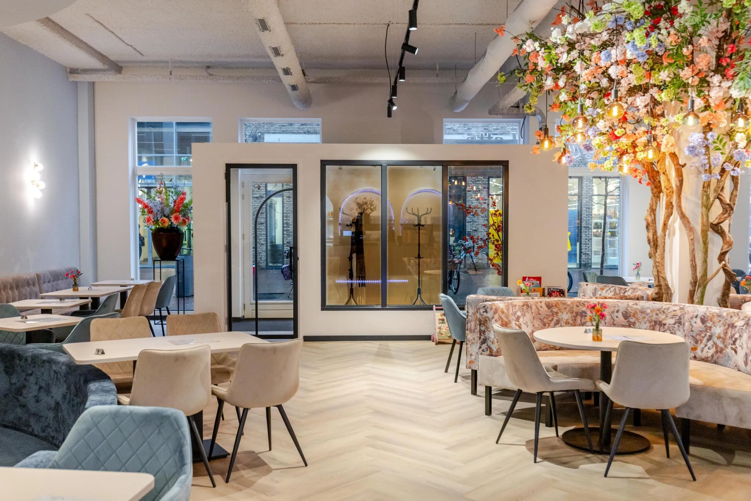 Een modern ingerichte eetgelegenheid met kleurrijke decoraties en bloemstukken.