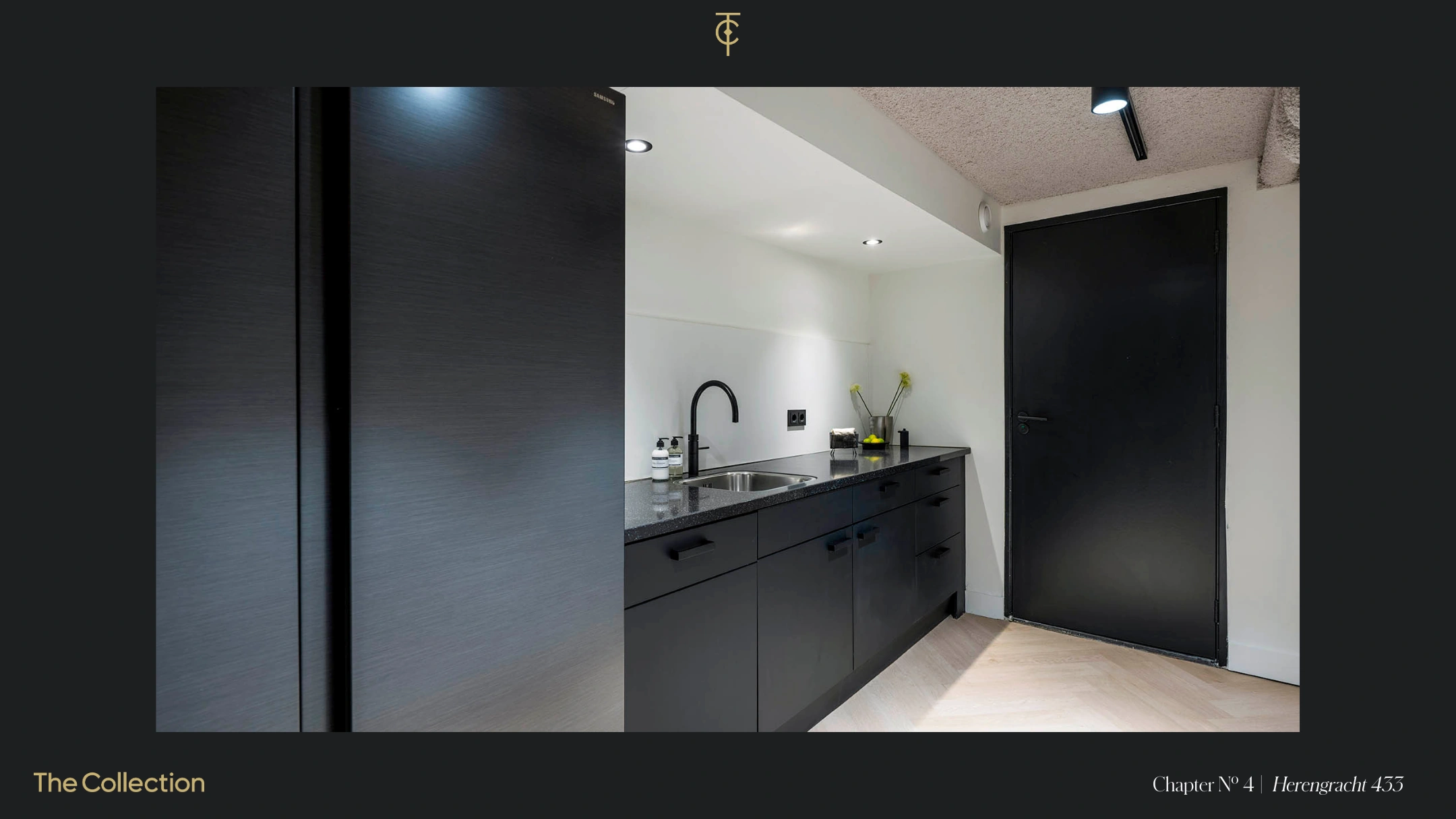 Een moderne keuken met donkere kastjes en een zwart werkblad in een minimalistisch interieur.