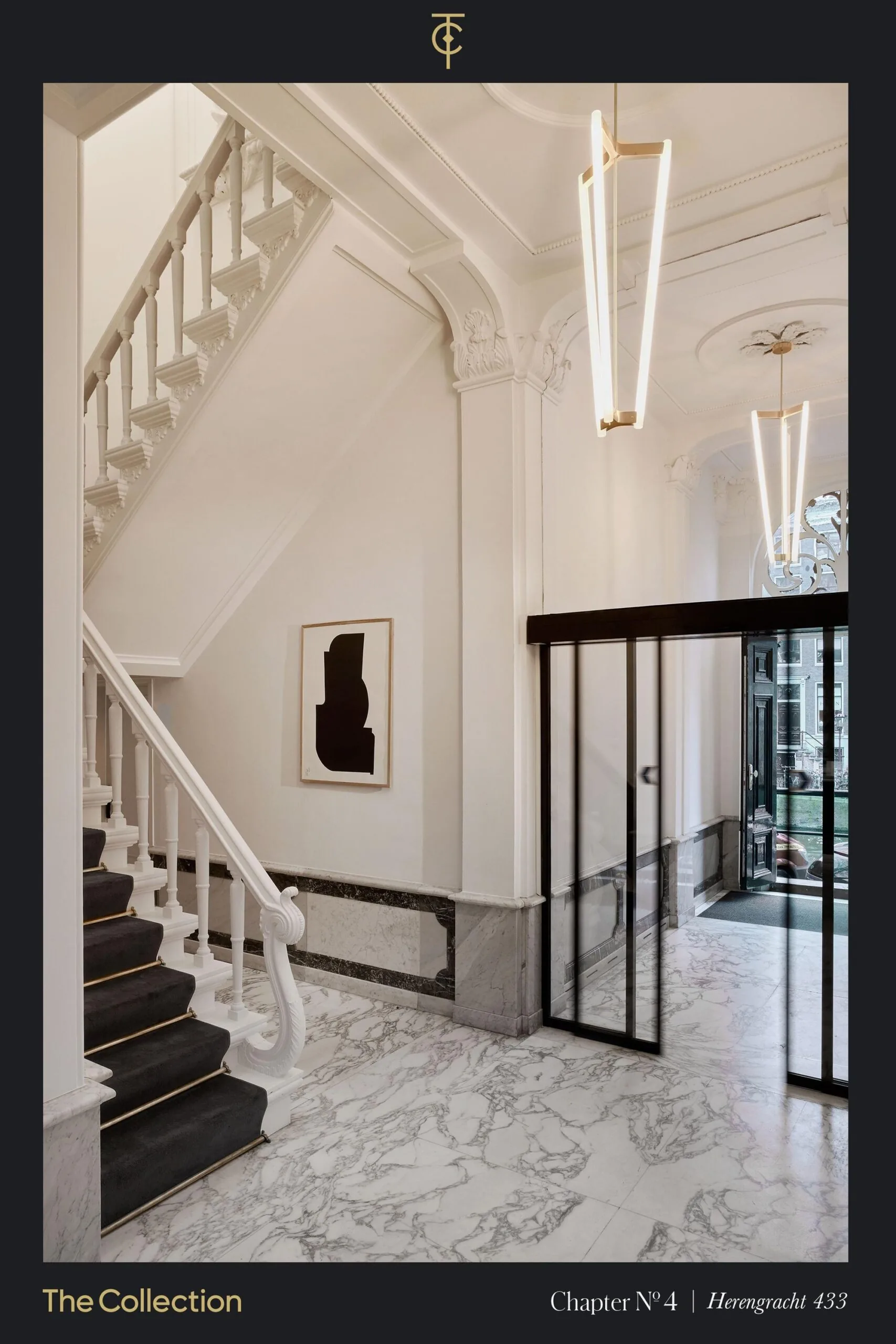 Een elegante ingang van het gebouw aan de Herengracht met een marmeren vloer en moderne verlichting.