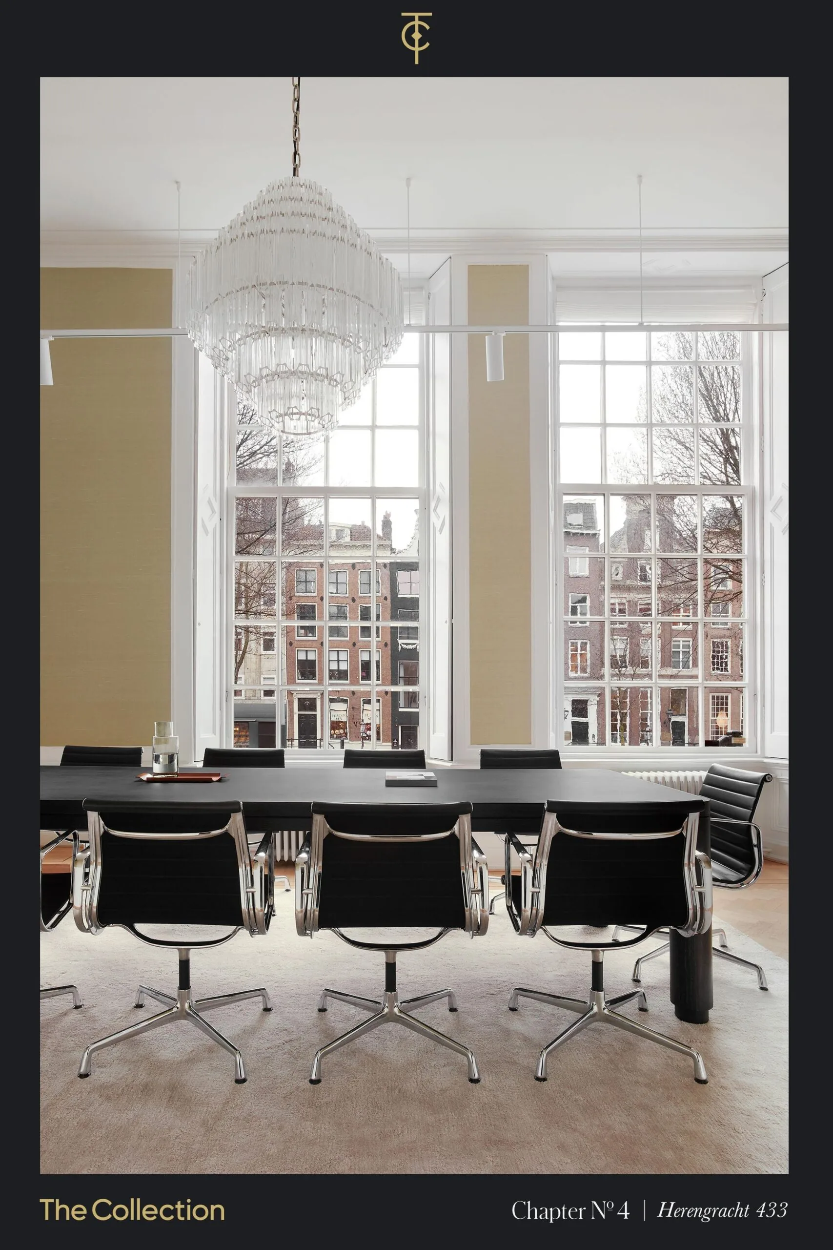 Vergaderruimte met moderne stoelen en een grote kroonluchter aan het plafond, met uitzicht op grachtenpanden aan de Herengracht.