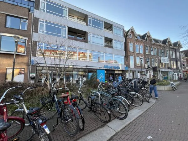 Een rij fietsen geparkeerd voor de Albert Heijn aan de Burgemeester Reigerstraat.