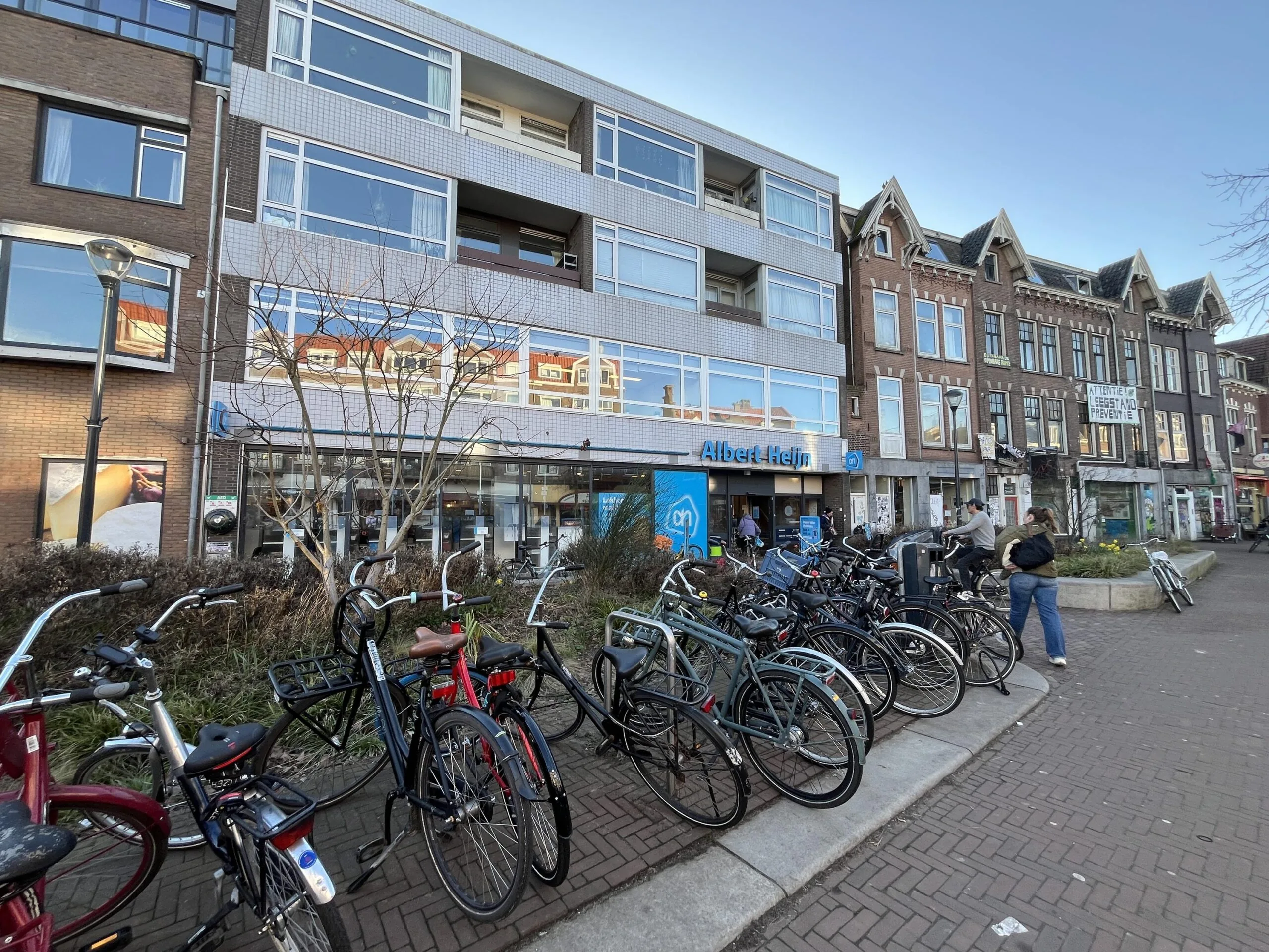 Een rij fietsen geparkeerd voor de Albert Heijn aan de Burgemeester Reigerstraat.
