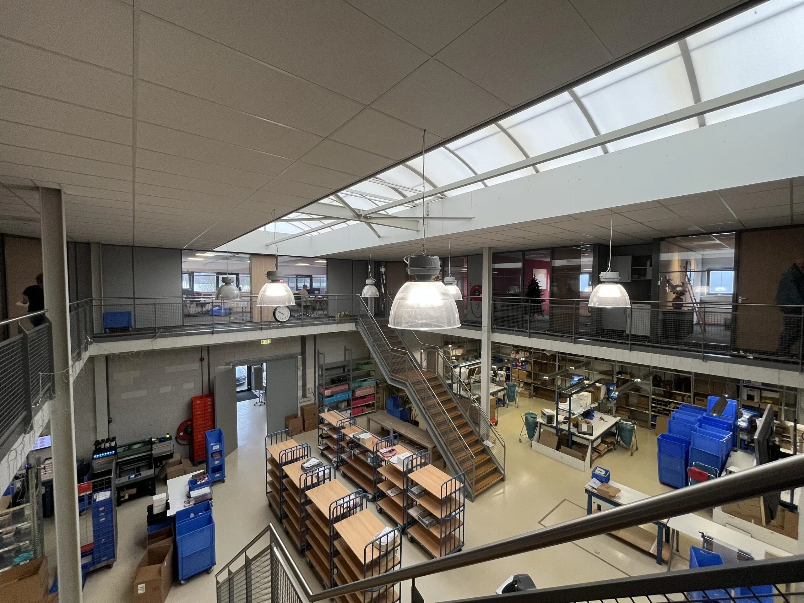 Interieur van een moderne werkplaats met opslag en kantoren op twee verdiepingen.