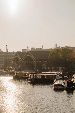 Zicht op boten en een historische scheepswerf aan de Hoogte Kadijk bij zonsopgang.