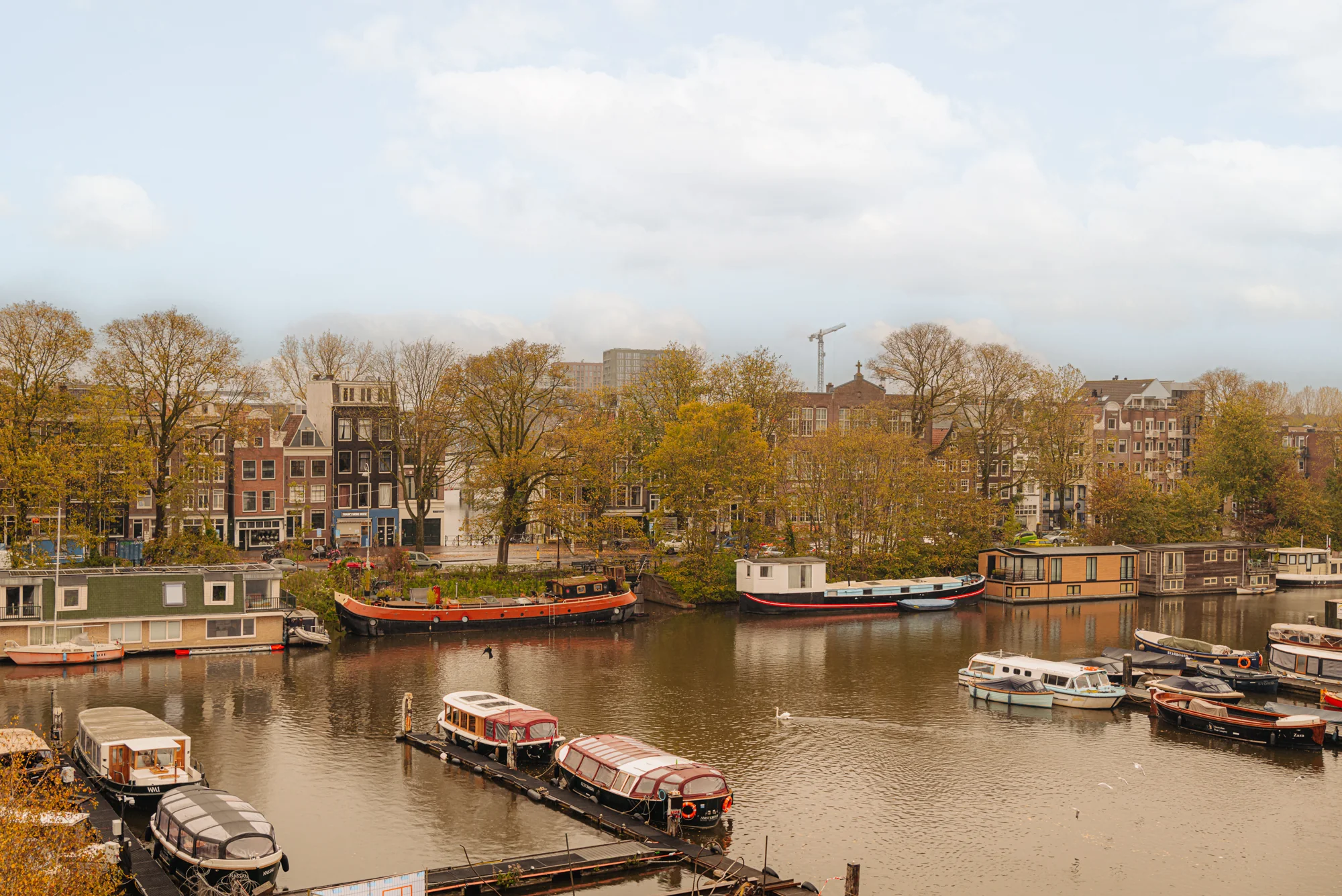 Uitzicht op de Hoogte Kadijk met aangemeerde boten en traditionele gebouwen langs het water.