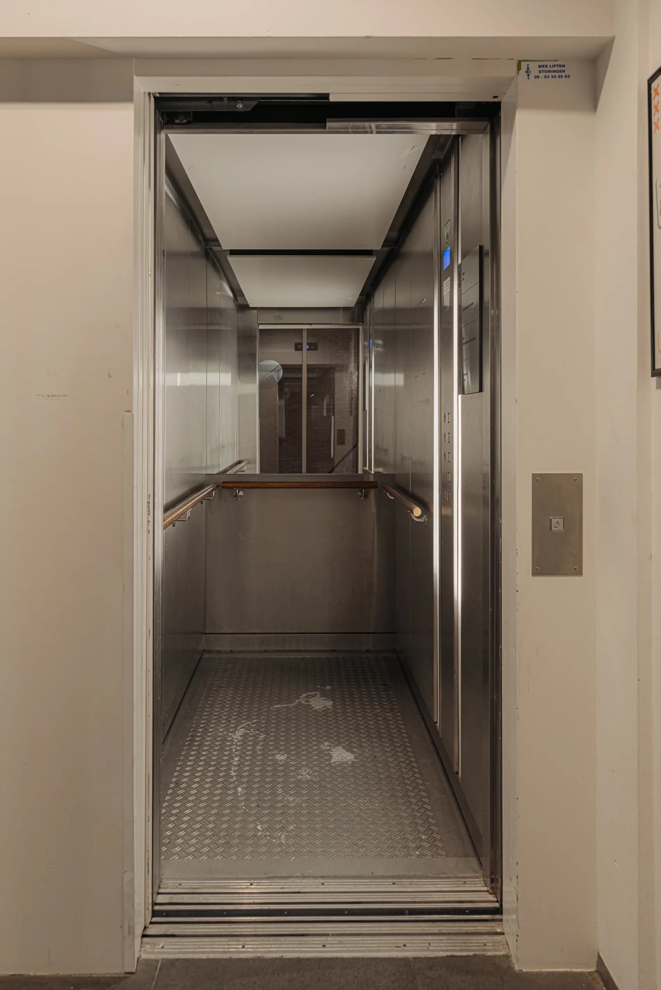 Openstaande lift met metalen interieur in een gebouw aan de Hoogte Kadijk.