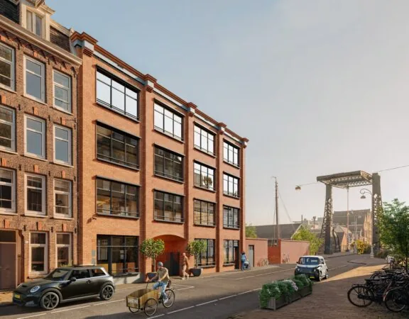 Straatbeeld in de Hoogte Kadijk met bakfietsen en auto's voor een rij historische en moderne bakstenen gebouwen, nabij een ijzeren brug.