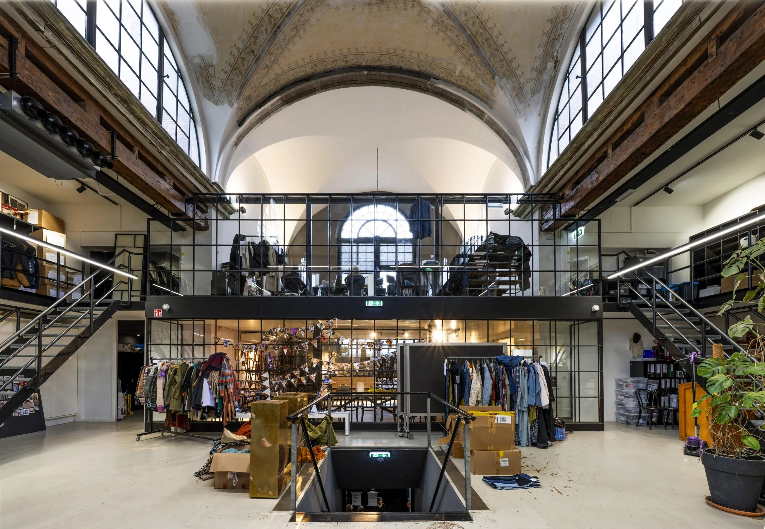 Interieur van een winkelruimte aan de Keizersgracht met hoge plafonds en kledingrekken.
