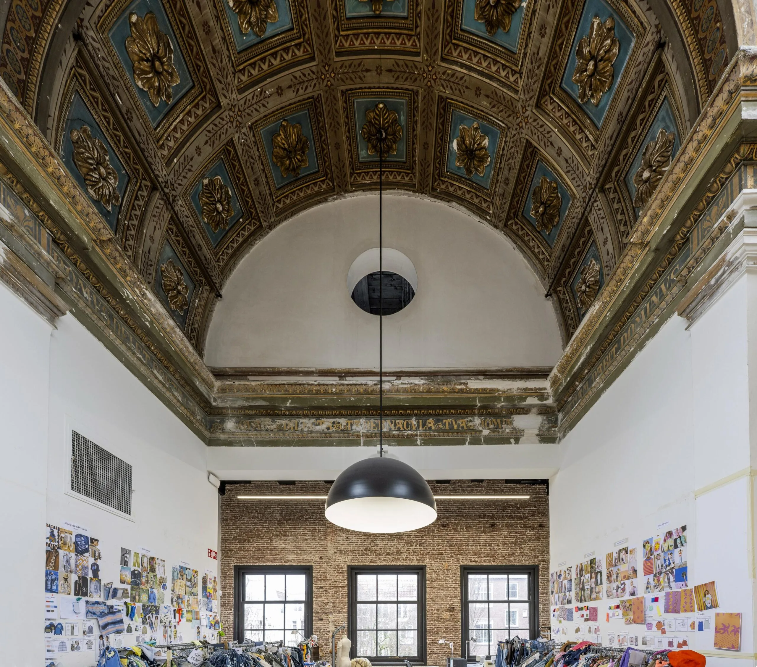 Interieur van een ruimte aan de Keizersgracht met een gedecoreerd gewelfd plafond en creatieve werkplekken.