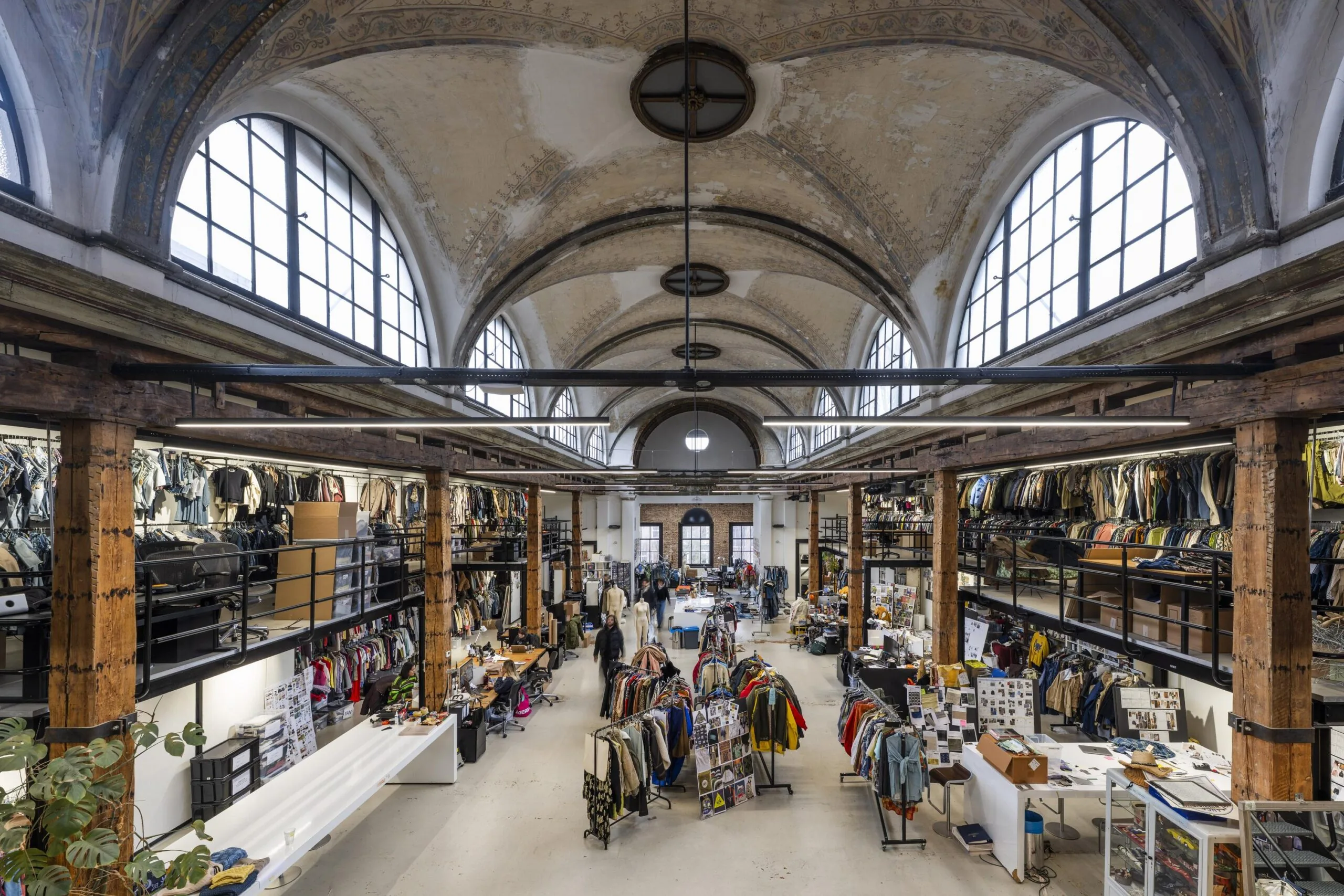 Een ruime, historisch ogende winkel op de Keizersgracht gevuld met kledingrekken en tafels vol modeartikelen.