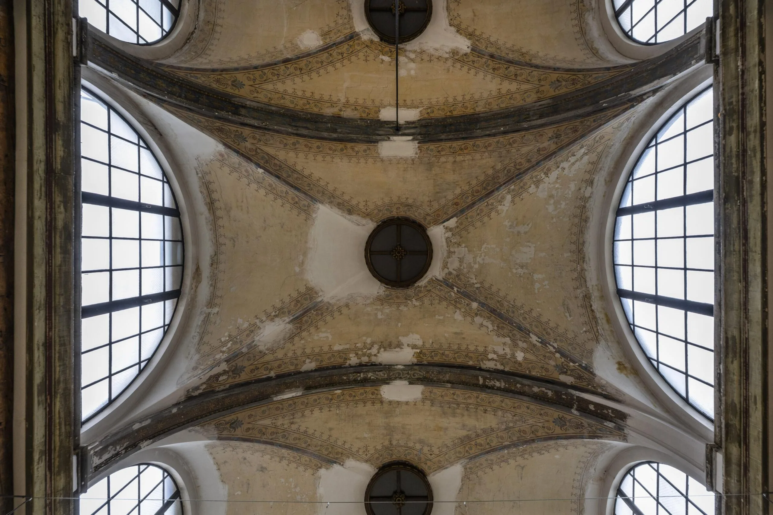 Plafond van een historische ruimte met ronde ramen en gedetailleerde ornamenten aan de Keizersgracht.
