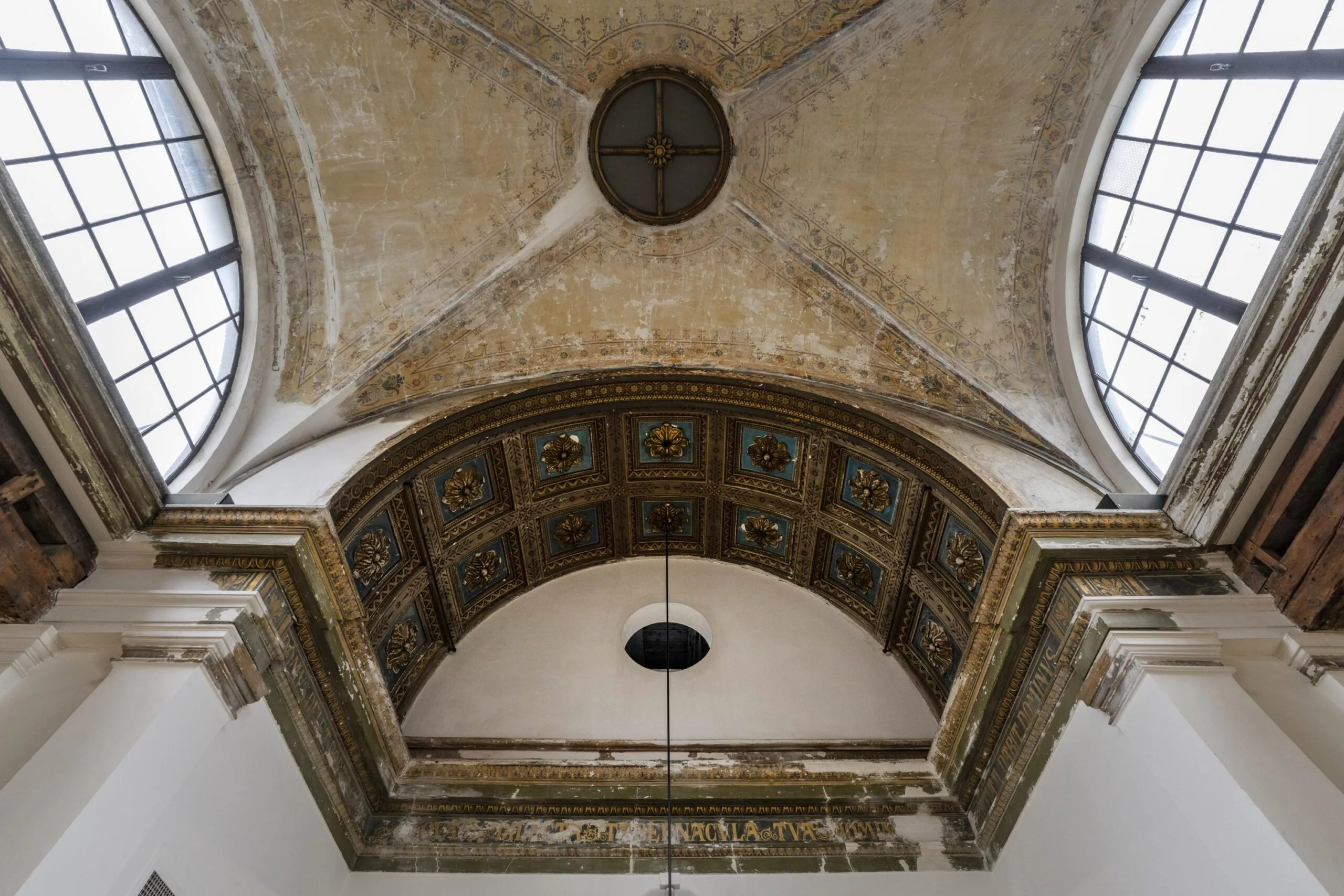 Plafond van het interieur aan de Keizersgracht met ornamenten en een grote boog met ramen.