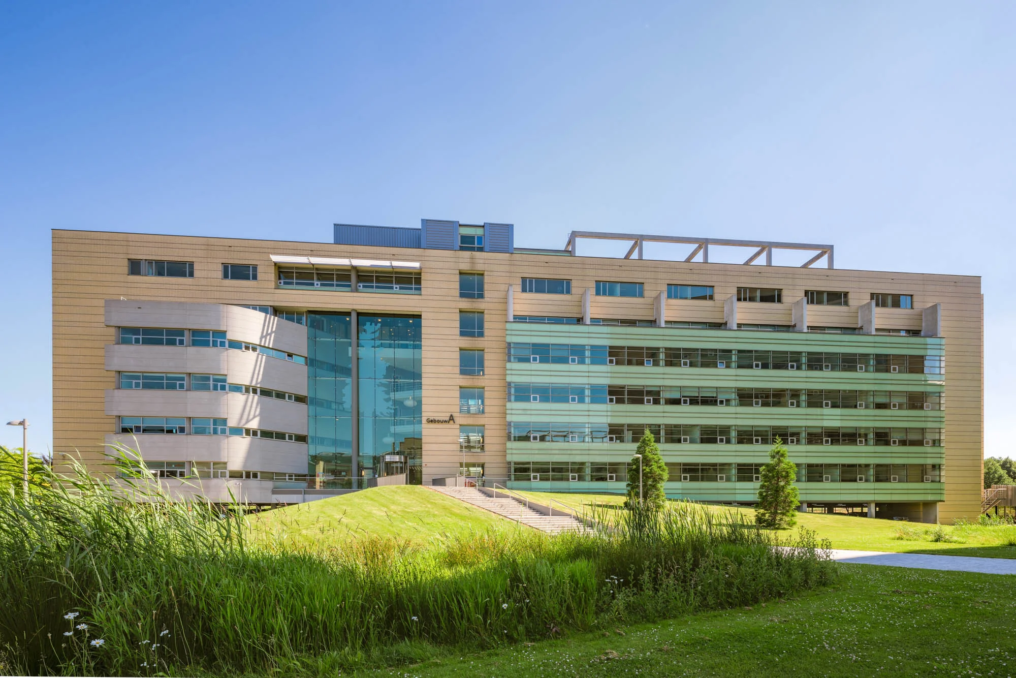 Een modern kantoorgebouw aan de Papendorpseweg omgeven door gras en planten.