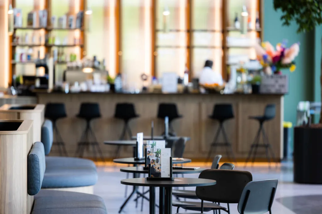 Een moderne koffiebar met hoge stoelen en tafeltjes in Papendorpseweg.