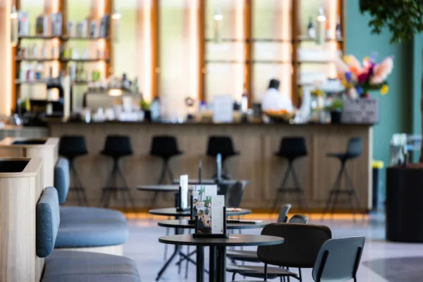 Een moderne koffiebar met hoge stoelen en tafeltjes in Papendorpseweg.