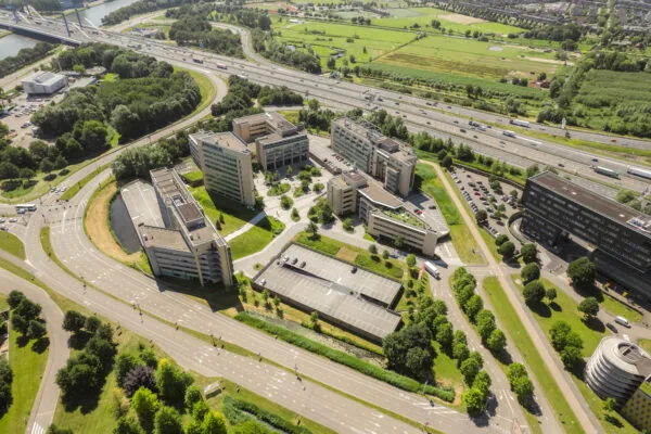 Luchtfoto van moderne kantoorgebouwen aan de Papendorpseweg, omringd door wegen en groene ruimtes.