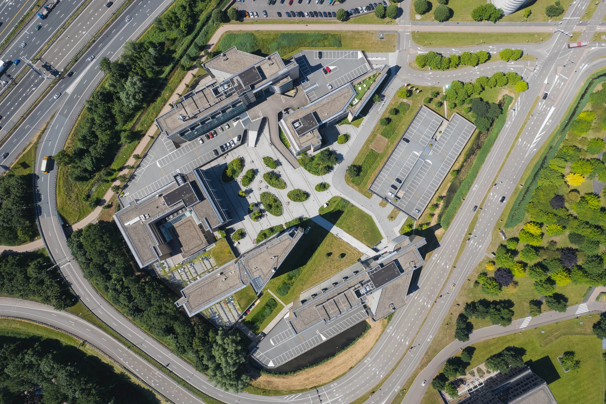 Luchtfoto van een kantoorgebouw met omliggende wegen en parkeerplaatsen aan de Papendorpseweg.