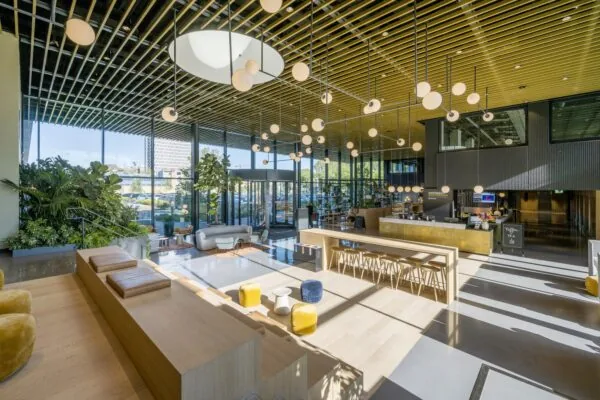 Een moderne lobby met veel natuurlijk licht, een zithoek en een café, gelegen aan de Spaklerweg.