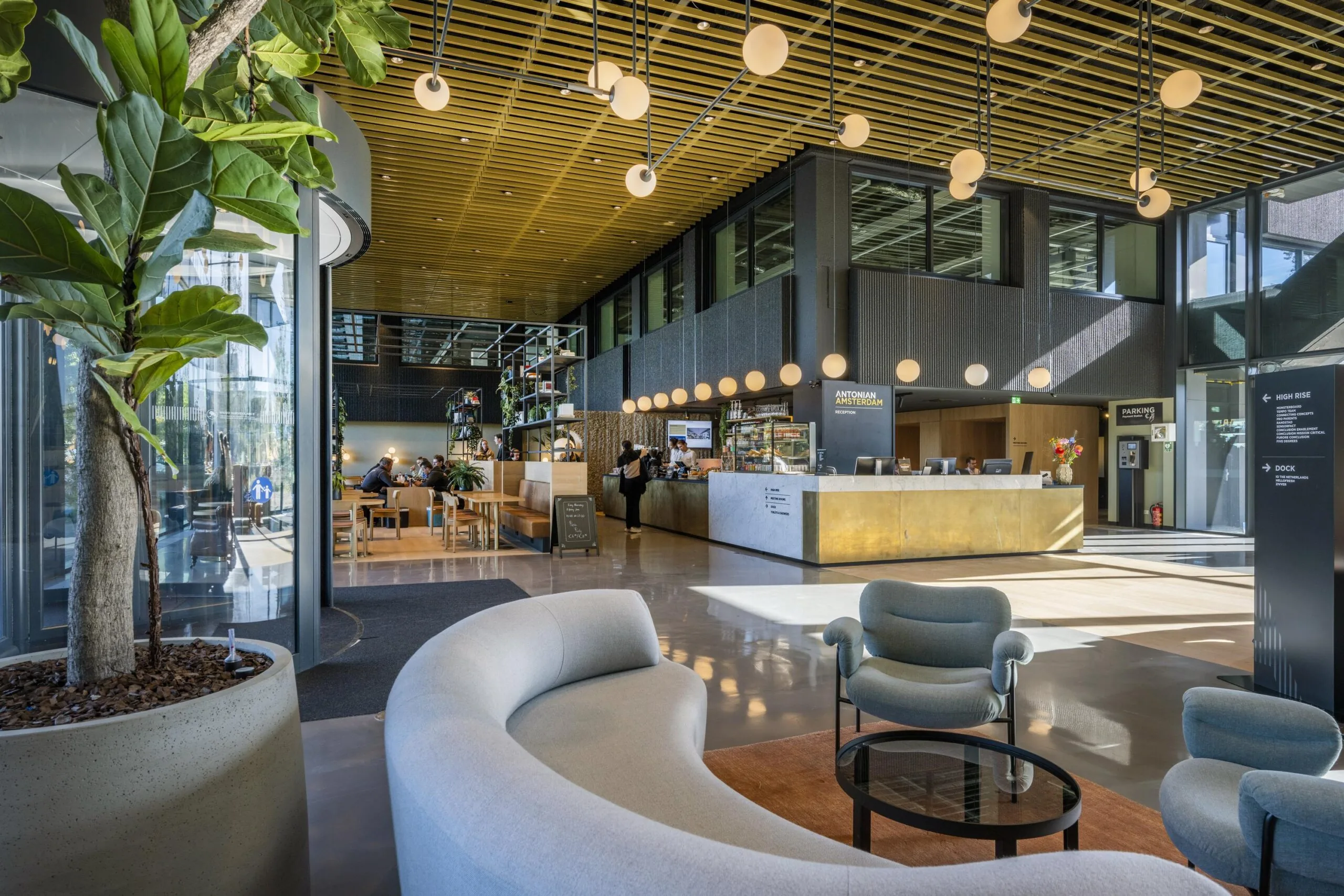 Een moderne en lichte lobby met een receptiebalie en comfortabele zitgedeeltes aan de Spaklerweg.