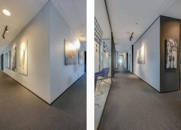 Een moderne, lichte gang in het Gustav Mahlerplein met kunstwerken aan de muren.