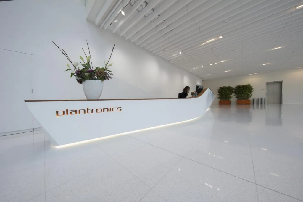 Een moderne receptiebalie in een strak kantoor met het logo van Plantronics.