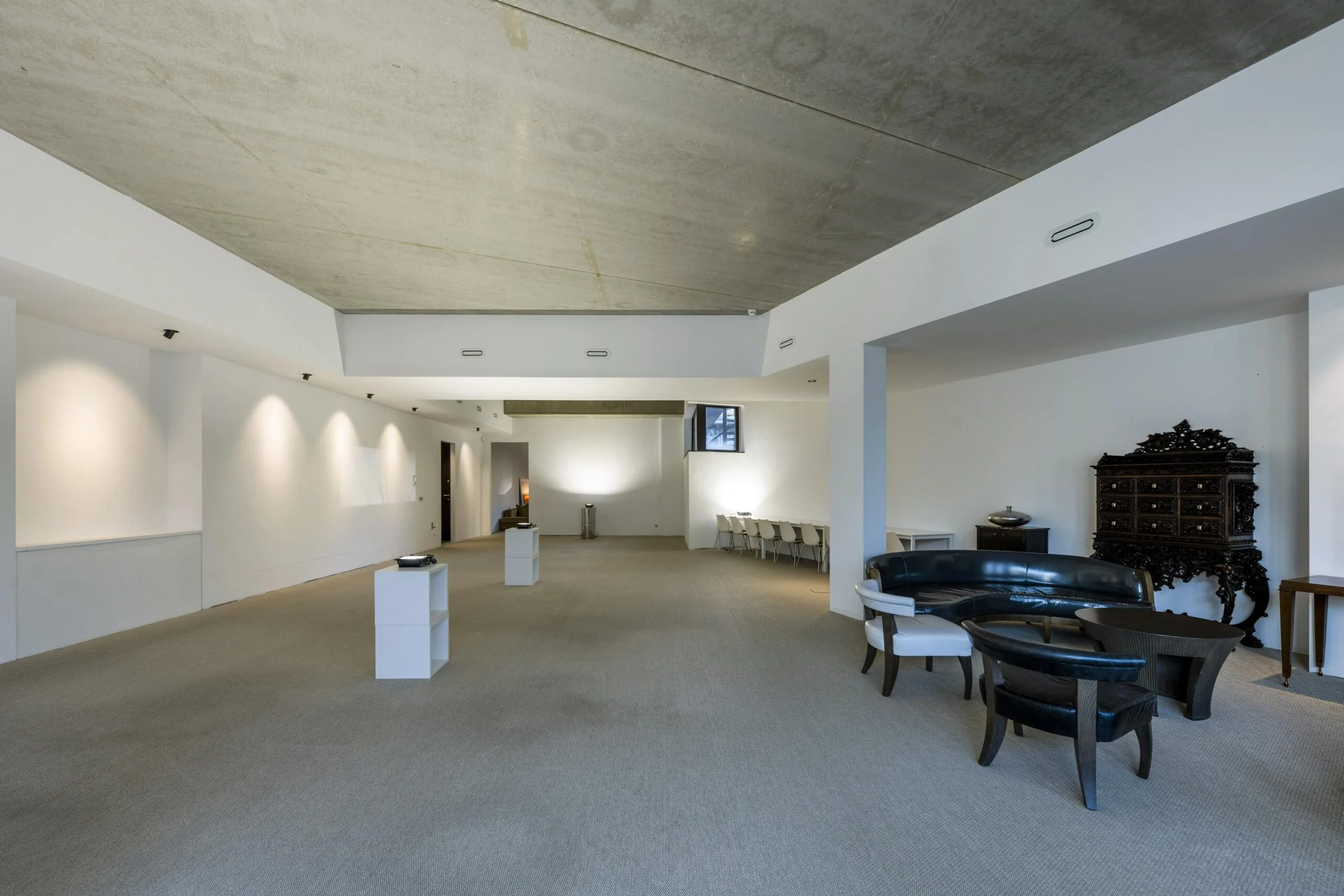 Ruime, moderne zaal met minimalistische inrichting en een sierlijk houten dressoir.
