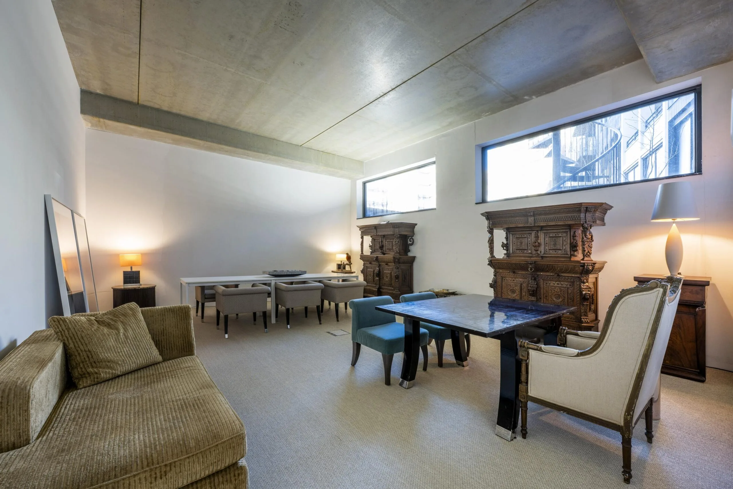 Een modern ingerichte kamer met houten meubels, een bank en een ruime tafel.