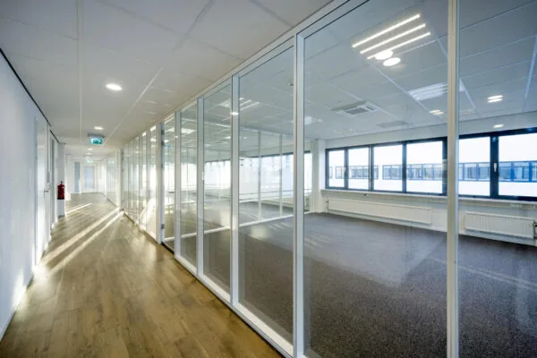 Een leeg kantoor met glazen wanden en een houten vloer, gelegen aan de Atoomweg.