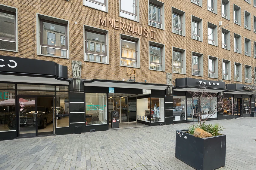 Gevel van het Minervahuis II met verschillende winkels op de begane grond, waaronder een Volvo dealer.