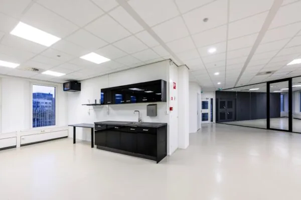 Een moderne, lege kantoorruimte met een kitchenette en glazen wanden in de Neptunusstraat.