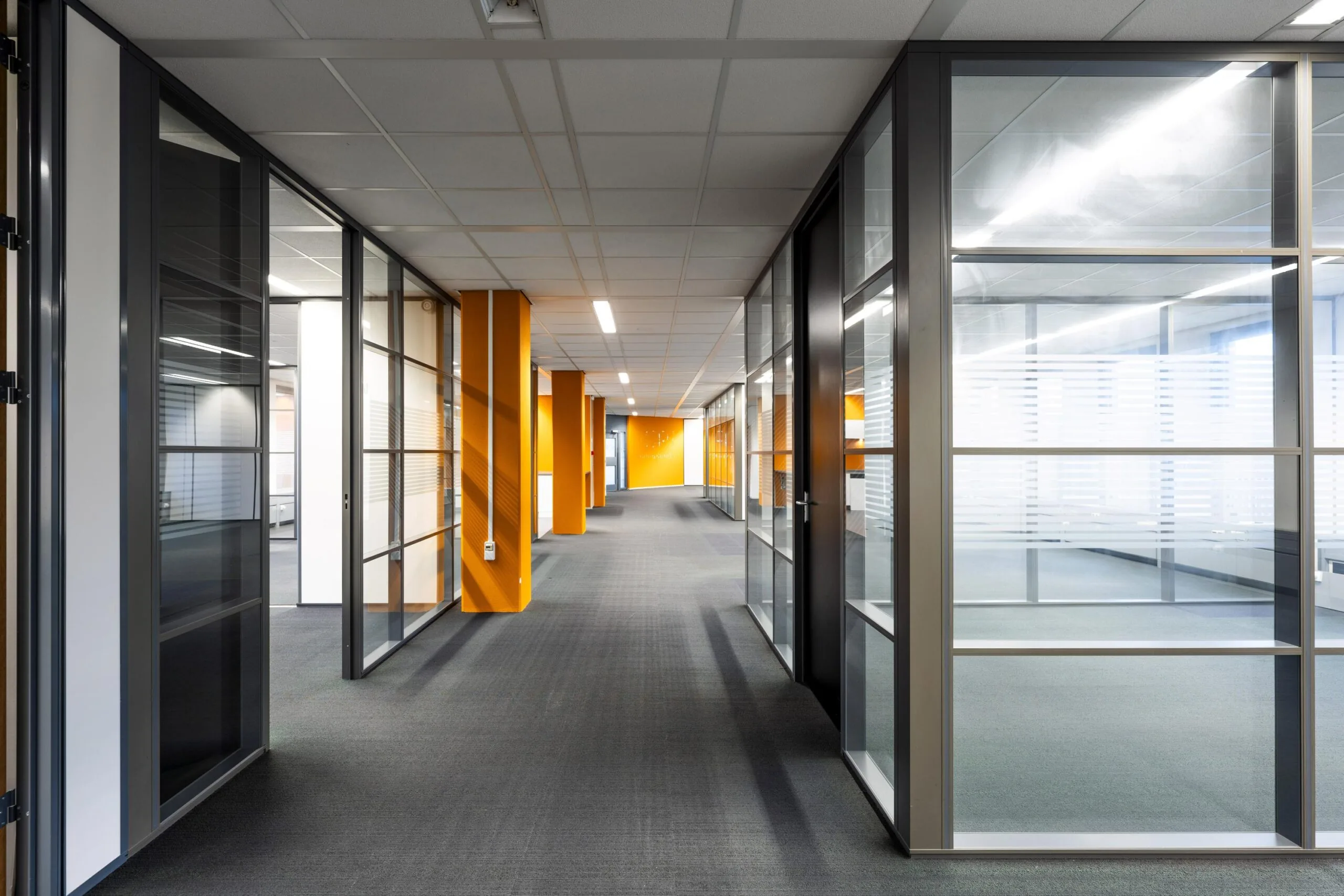 Een moderne kantoorhal met glazen wanden en oranje accenten op de Neptunusstraat.
