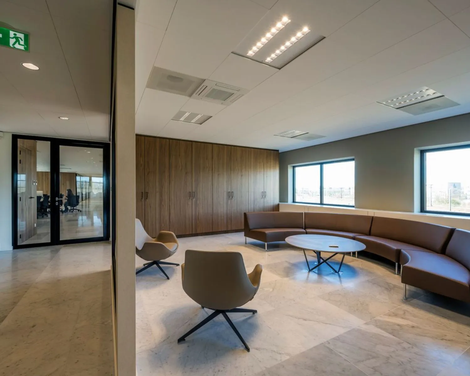 Moderne kantoorruimte aan de Wegalaan 35 in Hoofddorp met zithoek, ronde tafel en grote ramen.