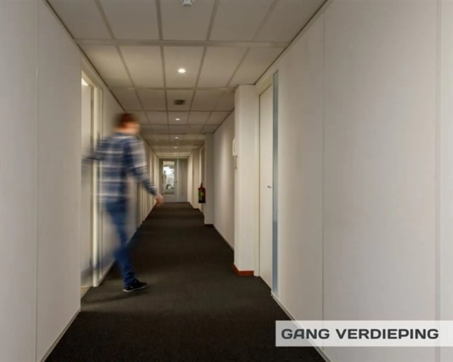 Moderne kantoorruimte met een zithoek, koffiecorner en grote wandafbeelding van windmolens.