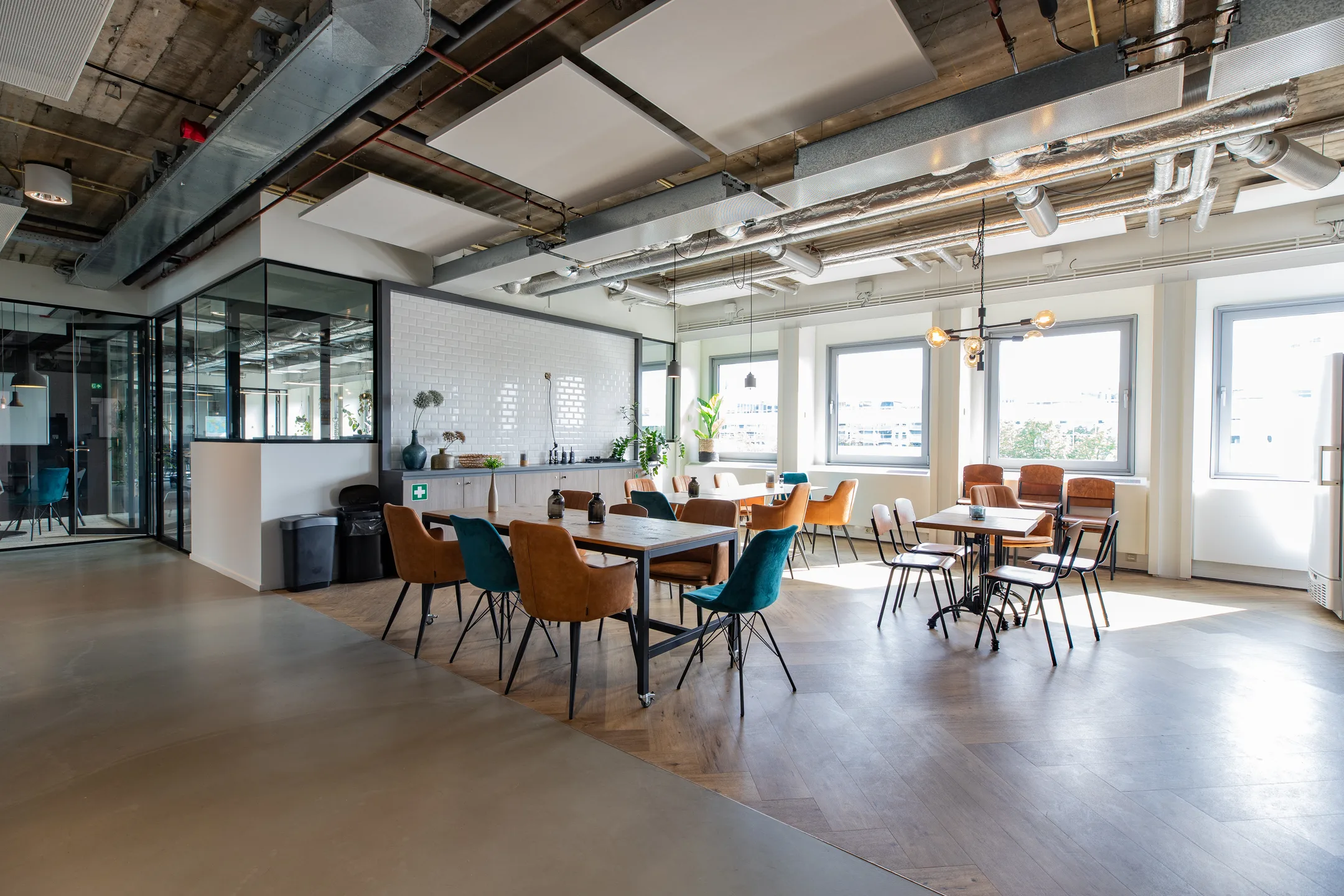 Een modern ingerichte kantineruimte met diverse tafels en stoelen.